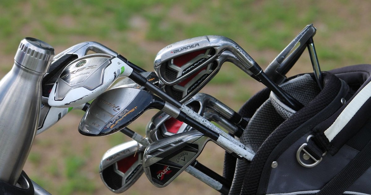 Irons and a water bottle in a golf bag