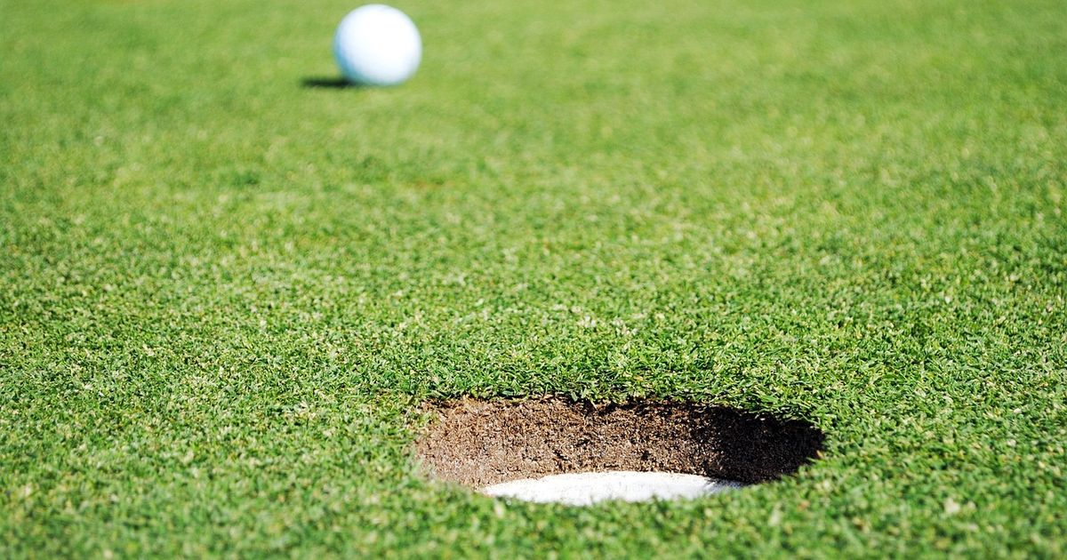 Golf ball on the green a few feet from the hole